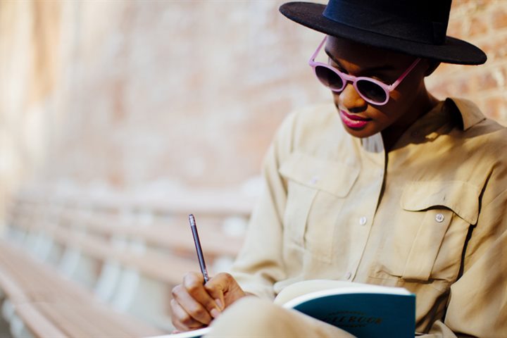 Artiste-auteure écrivant dans un carnet